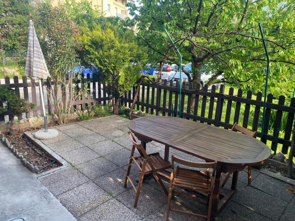 uma mesa de madeira e cadeiras ao lado de uma cerca em Apartment Fabiola em Sistiana