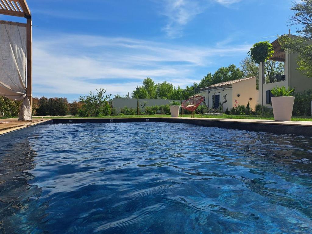 a swimming pool with blue water in a yard at Studio en campagne in Avignon
