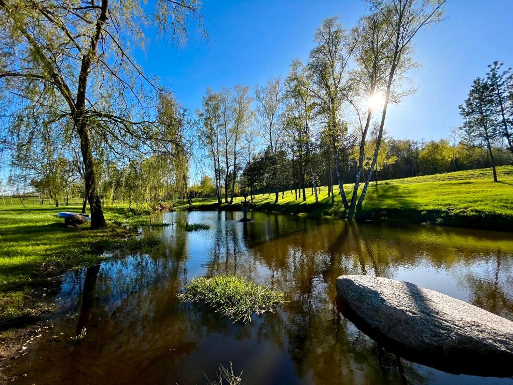 rzeka w parku z drzewami i trawą w obiekcie Lake House Family w mieście Wiewiecko