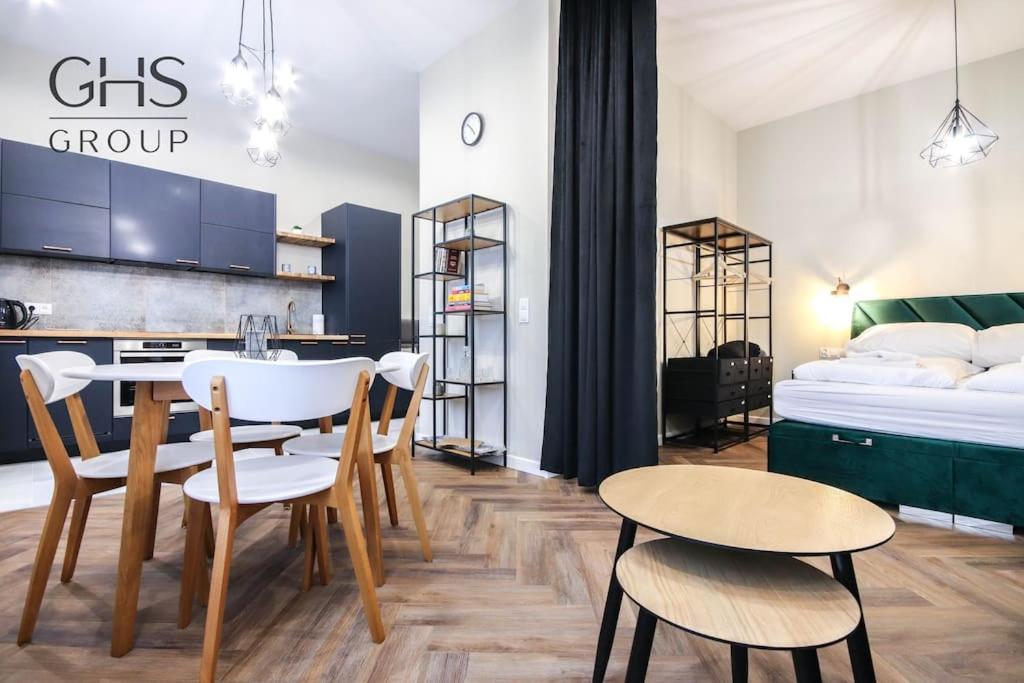 a room with a bed and a table and chairs at Designerski apartament w centrum Kazimierza in Krakow