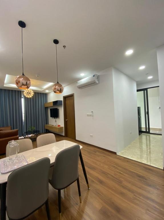 Asahi Luxstay - Green Pearl Bắc Ninh Serviced Apartment في Hòa Ðình: غرفة معيشة مع طاولة طعام وكراسي