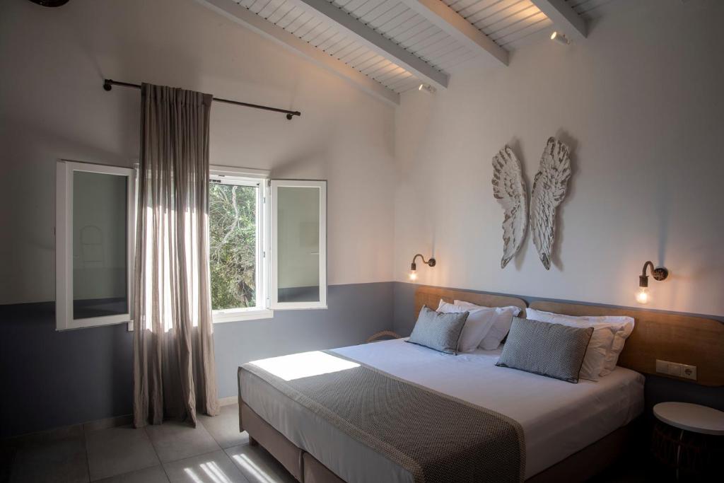 a bedroom with a large bed with a window at Avali luxury houses in Gaios