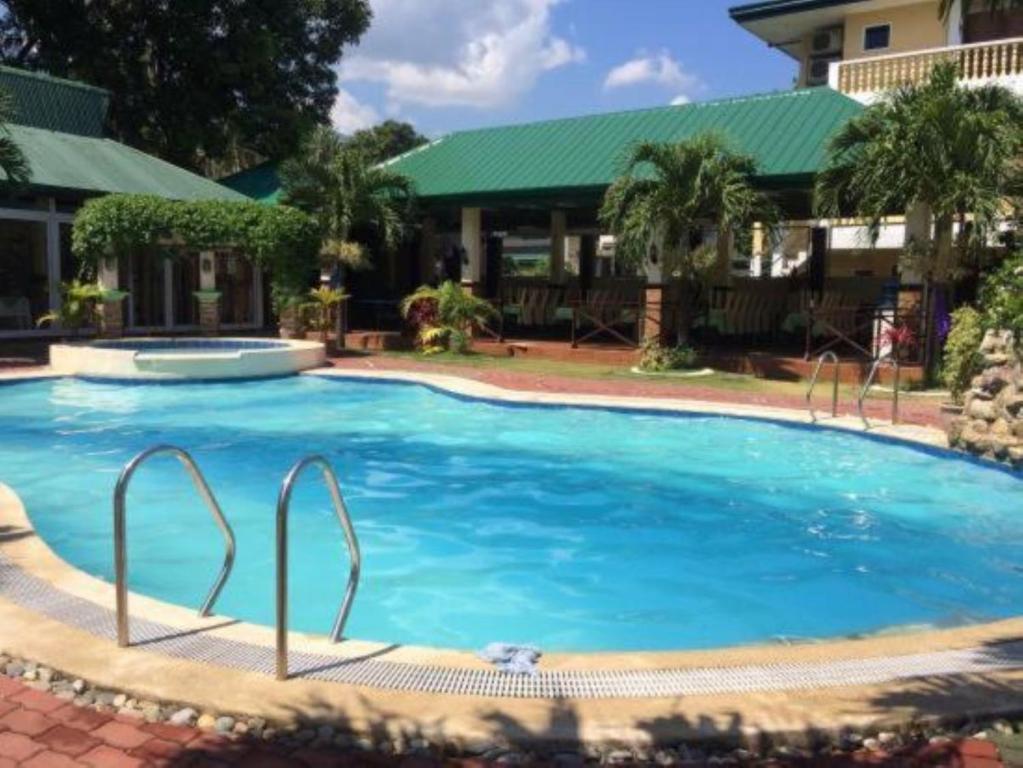 une grande piscine bleue en face d'une maison dans l'établissement La Solana Suites and Resorts by Cocotel, à Puerto Galera