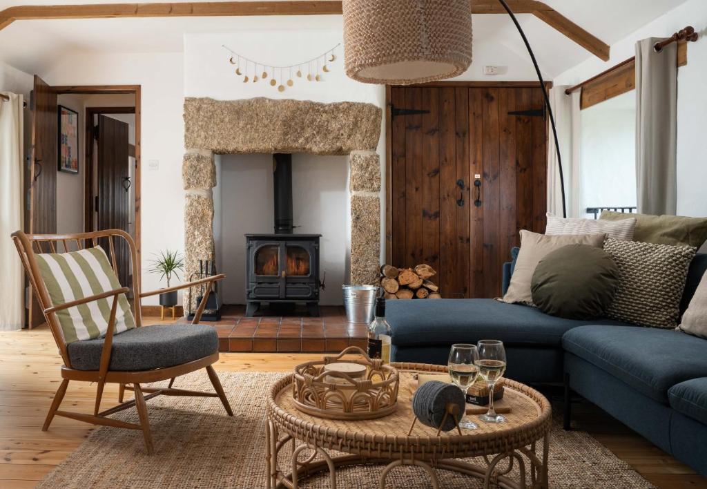 sala de estar con sofá azul y chimenea en Spacious & cosy cottage, walk to Porthcurno beach, Pedn Vouder, Minack & PK Museum en Penzance