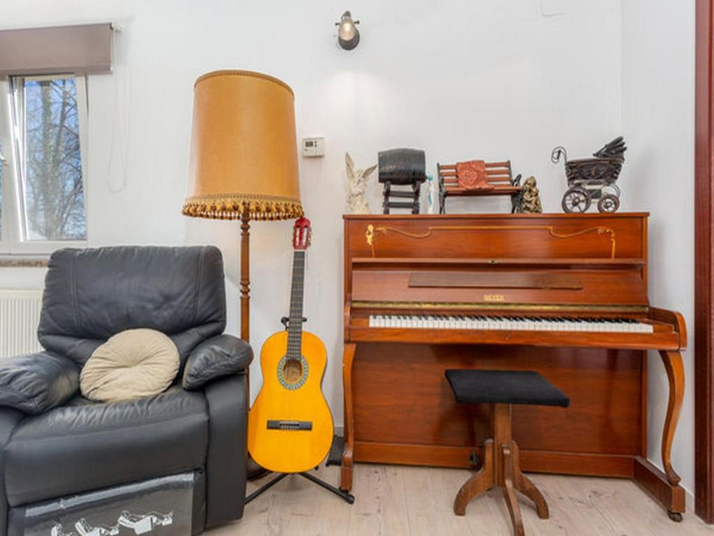 ein Wohnzimmer mit einem Klavier und einem Stuhl in der Unterkunft Apartment Brletic in Kastav