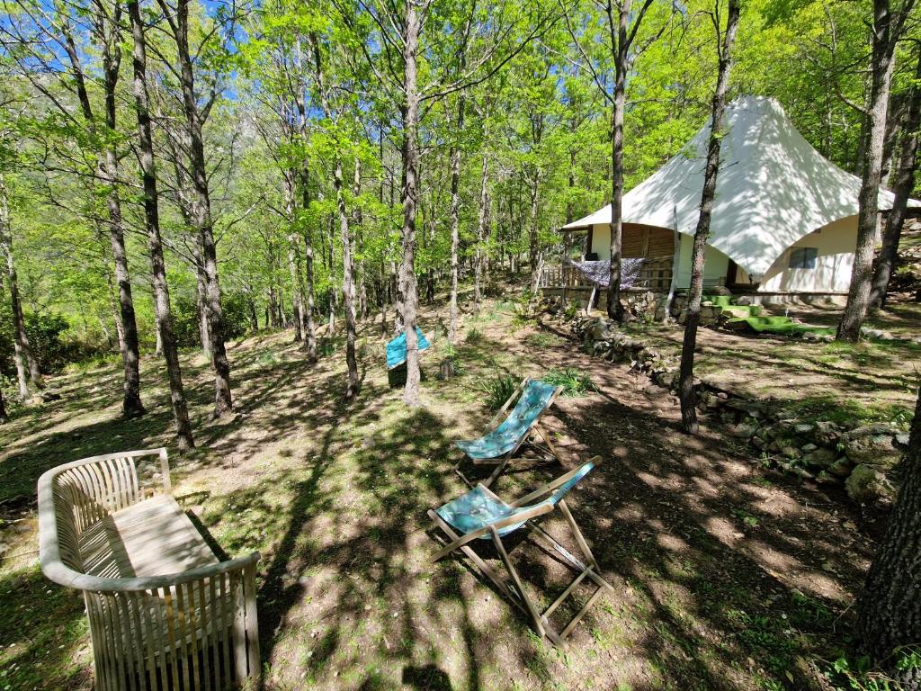 2 chaises et une maison dans les bois dans l'établissement Lodge de Charme 2 Chambres, à Ghisoni