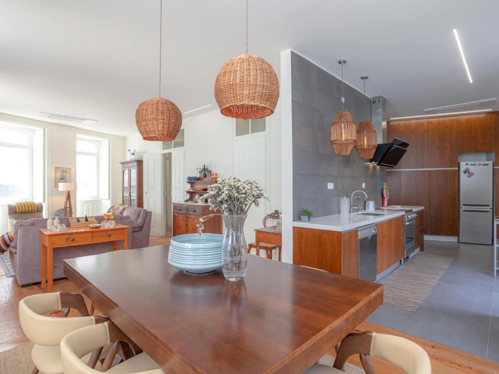 eine Küche und ein Wohnzimmer mit Tisch und Stühlen in der Unterkunft Casa do Poeta in Figueira da Foz