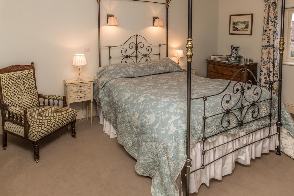 a bedroom with a large bed and a chair at High Park Farm in York
