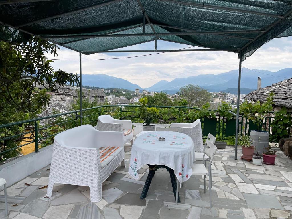 a table and chairs on a patio with a view at Guest House Bakuli in Gjirokastër