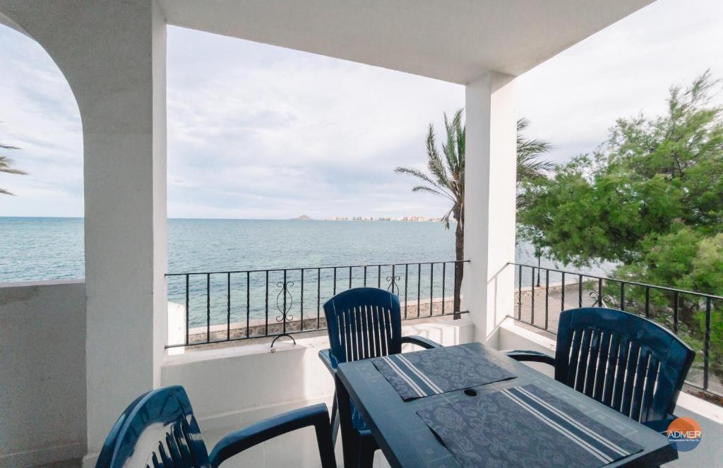 een balkon met een tafel en stoelen en de oceaan bij Aldeas Taray Admer 002 in La Manga del Mar Menor