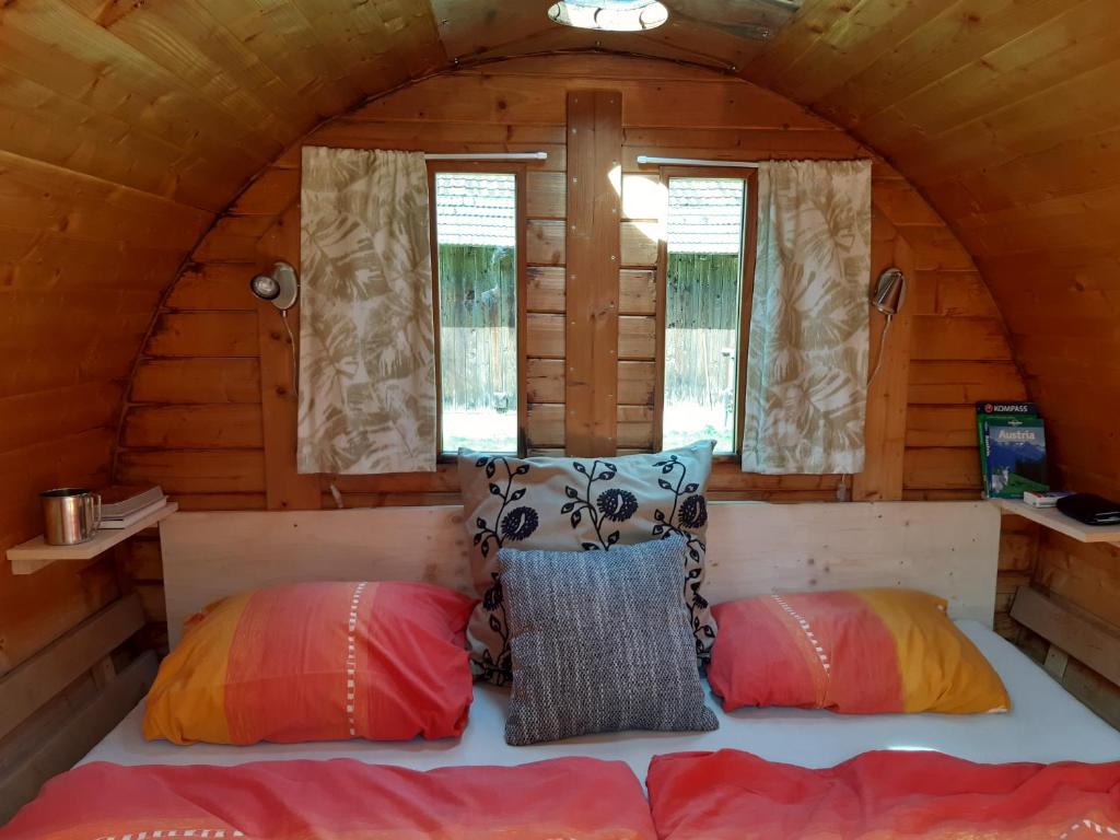 a bedroom in a log cabin with two pillows at Campingfass Almtal in Scharnstein