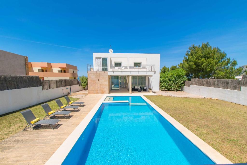 a villa with a swimming pool in front of a house at Casa Mut in Artá