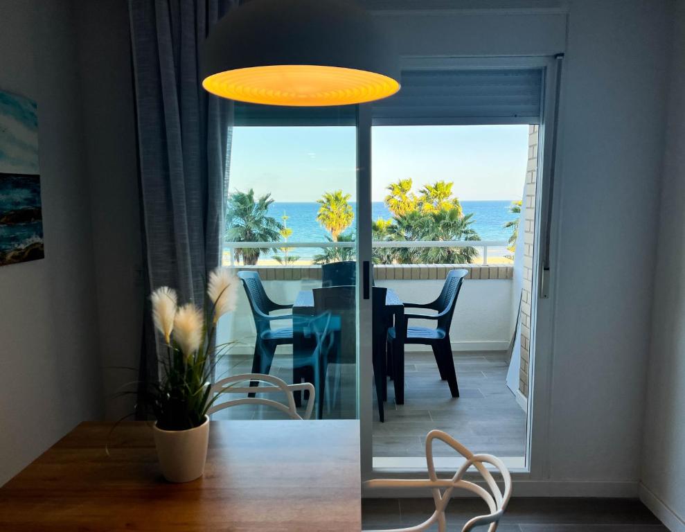 uma sala de jantar com uma mesa e vista para o oceano em Dorado Amanecer frente al Mar em Oropesa del Mar