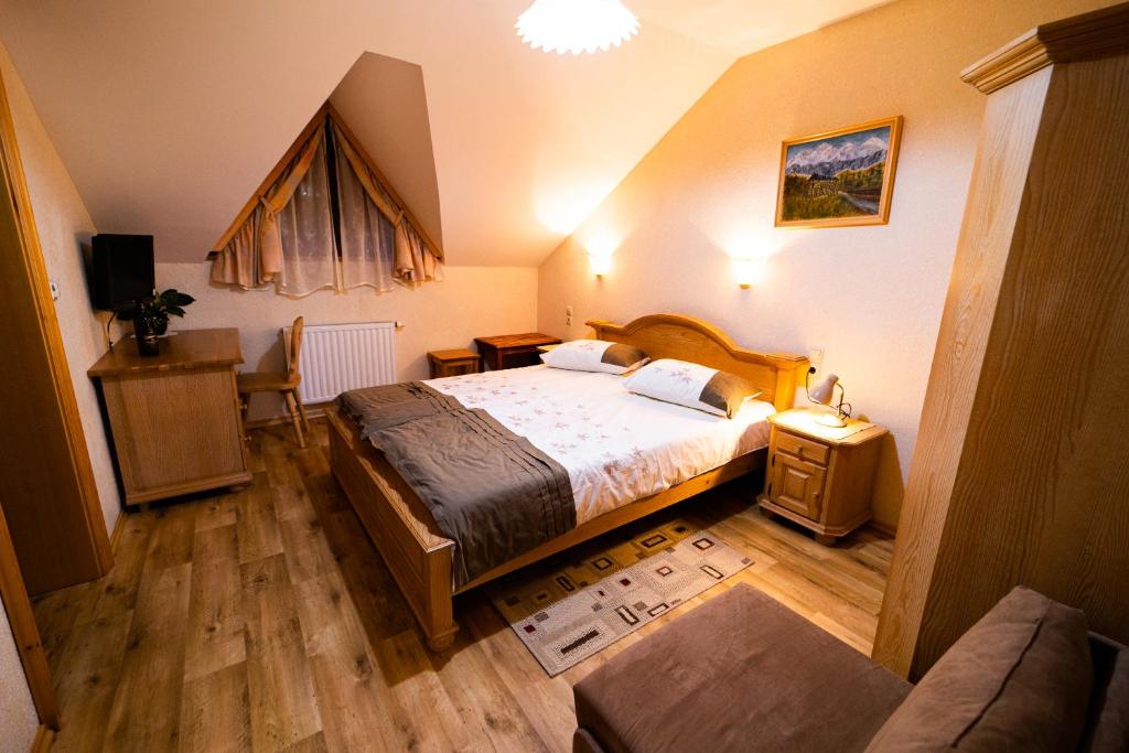 a bedroom with a bed and a table and a couch at Guesthouse Močivnik in Okroglice