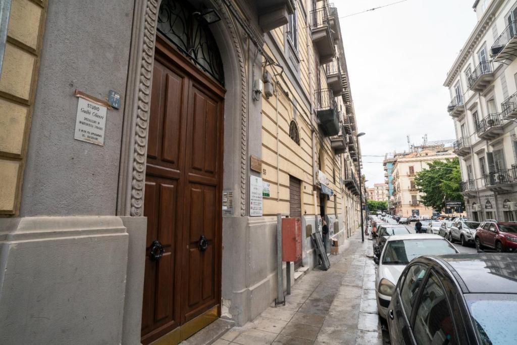 un edificio con una grande porta in legno su una strada di B&B Handy Palermo a Palermo