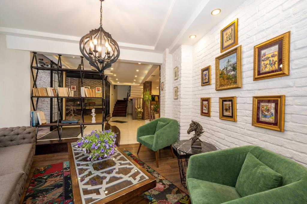 The marions Suite istanbul LUXURY CATEGORY في إسطنبول: غرفة معيشة مع كراسي خضراء وطاولة