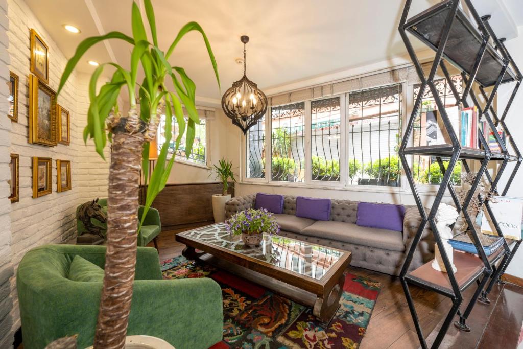 een woonkamer met een bank en een palmboom bij The marions Suite istanbul LUXURY CATEGORY in Istanbul