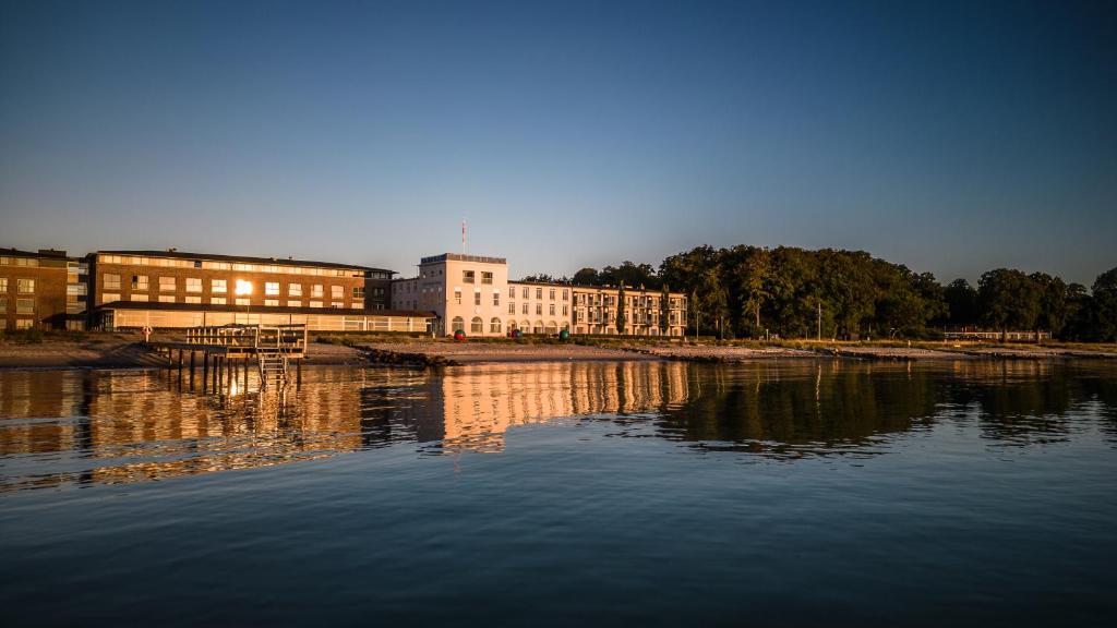 um grande edifício ao lado de uma massa de água em Nyborg Strand Hotel & Konference em Nyborg