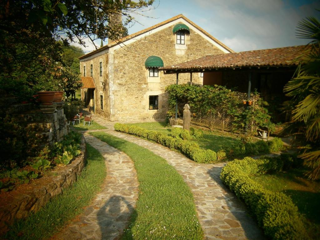 a stone building with a path leading to a house at Casa Dos Cregos in Bascuas