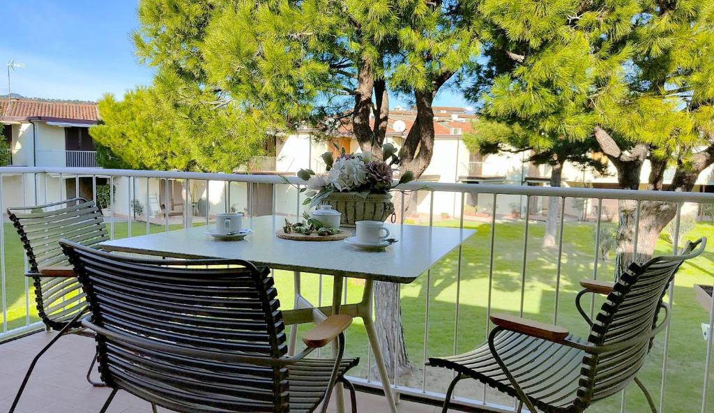 uma mesa e cadeiras sentadas numa varanda com uma mesa e uma espreguiçadeira em Appartamento Romantica 35 em Raffa