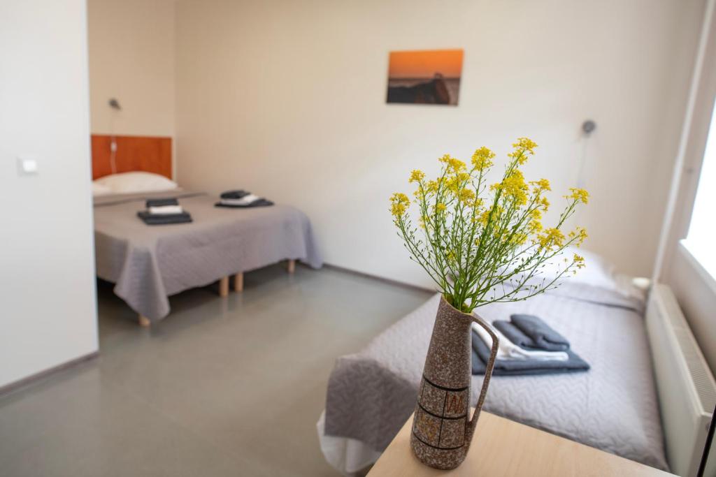 a room with a vase with yellow flowers on a table at Haapsalu Kutsehariduskeskuse hostel in Haapsalu