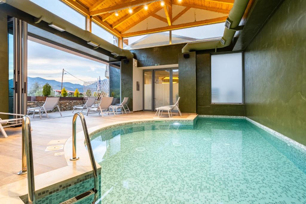 einen Pool in einem Haus mit einer Terrasse in der Unterkunft Denthis Hotel - Taygetos Mountain Getaway in Artemisía