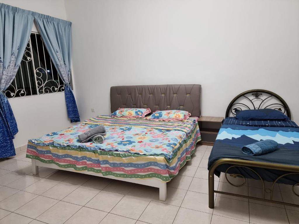 サンダカンにあるSweethome Homestay Sandakanのベッド2台と窓のある寝室