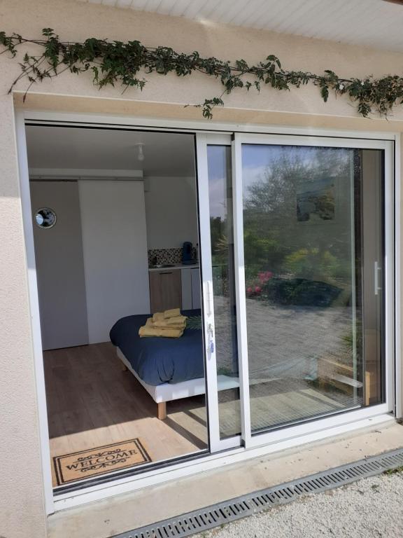 Camera con letto e porta scorrevole in vetro. di Chambre d'hôte Milin An Awel a Pleumeur-Bodou