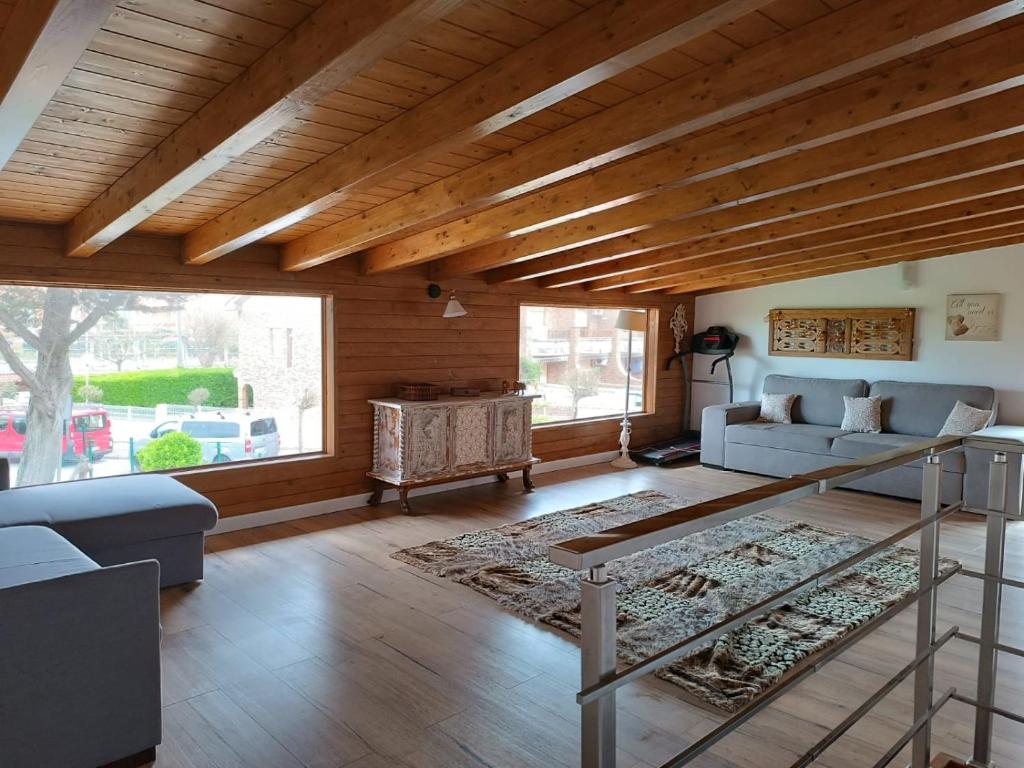 een woonkamer met houten plafonds en een groot raam bij Casa Playa Loredo in Loredo