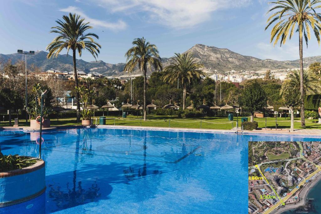 a large swimming pool with palm trees and mountains at BenalSun 100 meters from Beach in Benalmádena