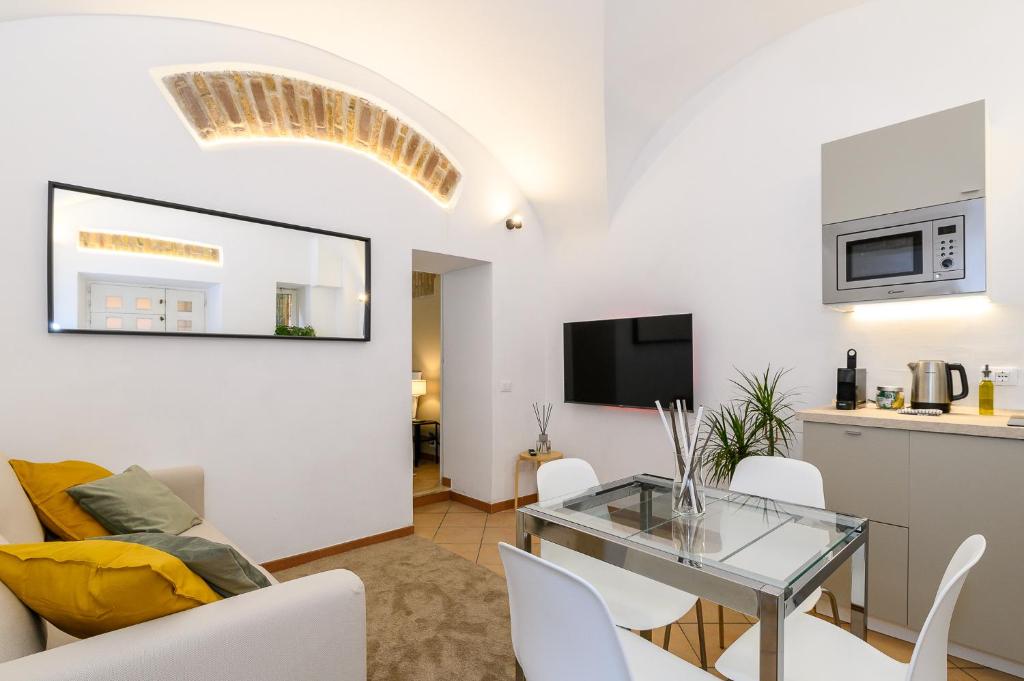 a living room with a glass table and white chairs at Cozy & Central with Private Entrance - NDP Rent in Rome