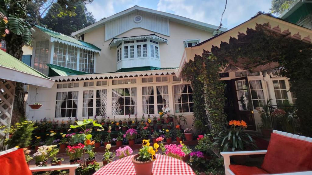 une maison avec des fleurs devant elle dans l'établissement Ivanhoe Hotel (A Heritage Property), à Darjeeling