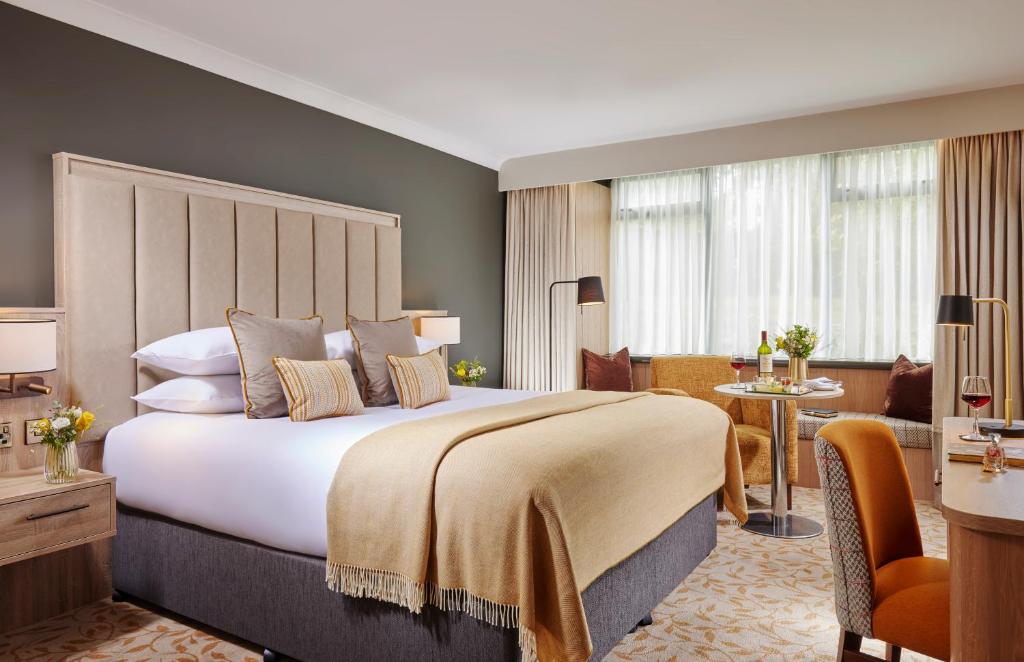 a bedroom with a large bed and a living room at Sligo Park Hotel & Leisure Club in Sligo