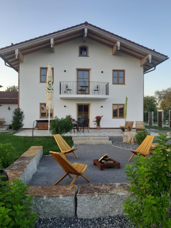 a house with two chairs and a patio at Ferienwohnungen Schneckenhausen in Pittenhart