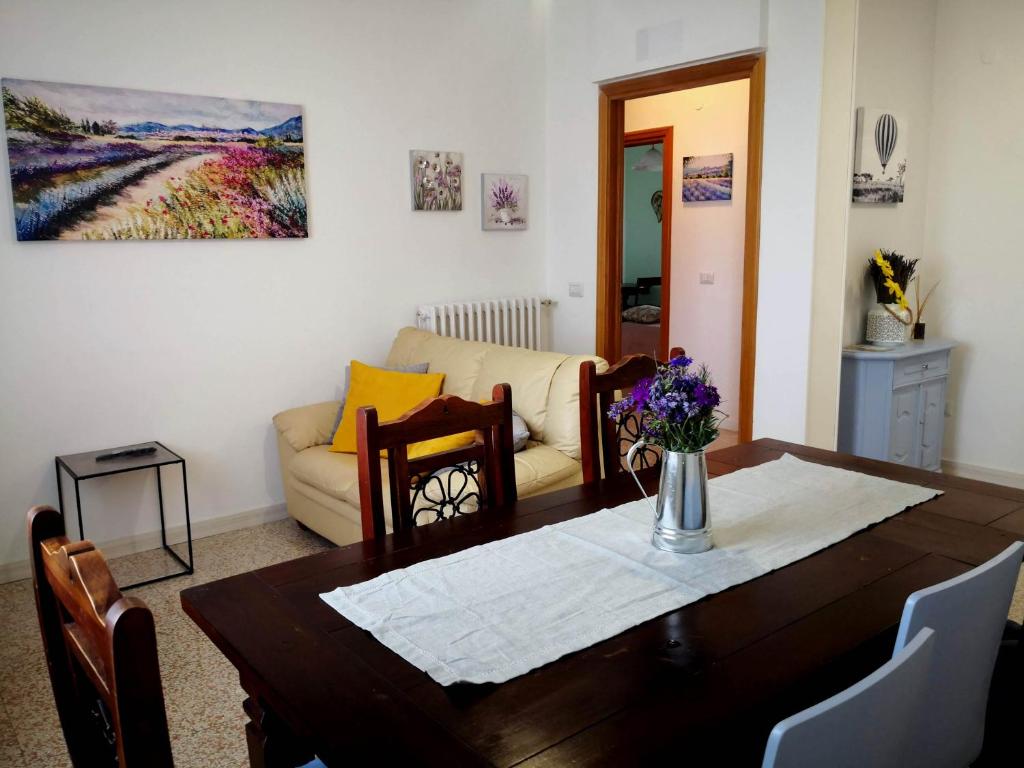 uma sala de estar com uma mesa e um sofá em Appartamento vacanze Assisi nel cuore em Costano