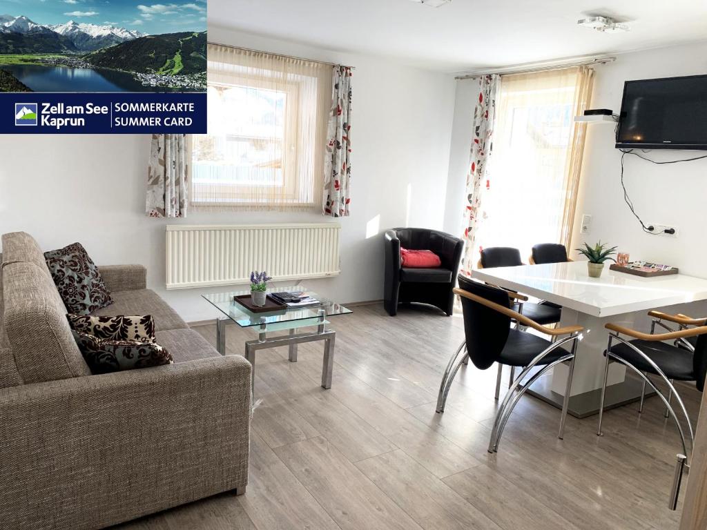 a living room with a couch and a table at Haus Schmitten – Austrian Alpine Getaways in Zell am See