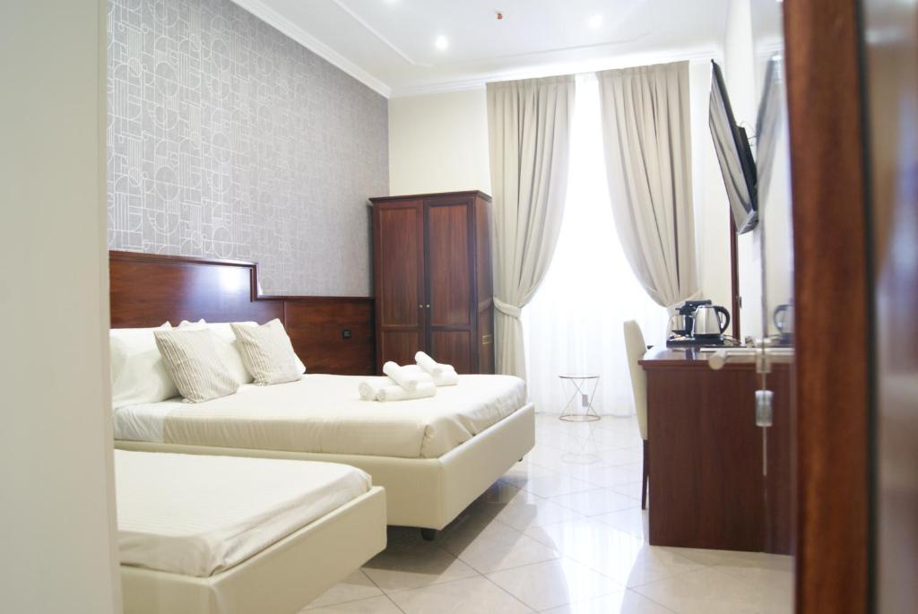 ローマにあるMonti 66 Hotelのベッド2台とテレビが備わるホテルルームです。