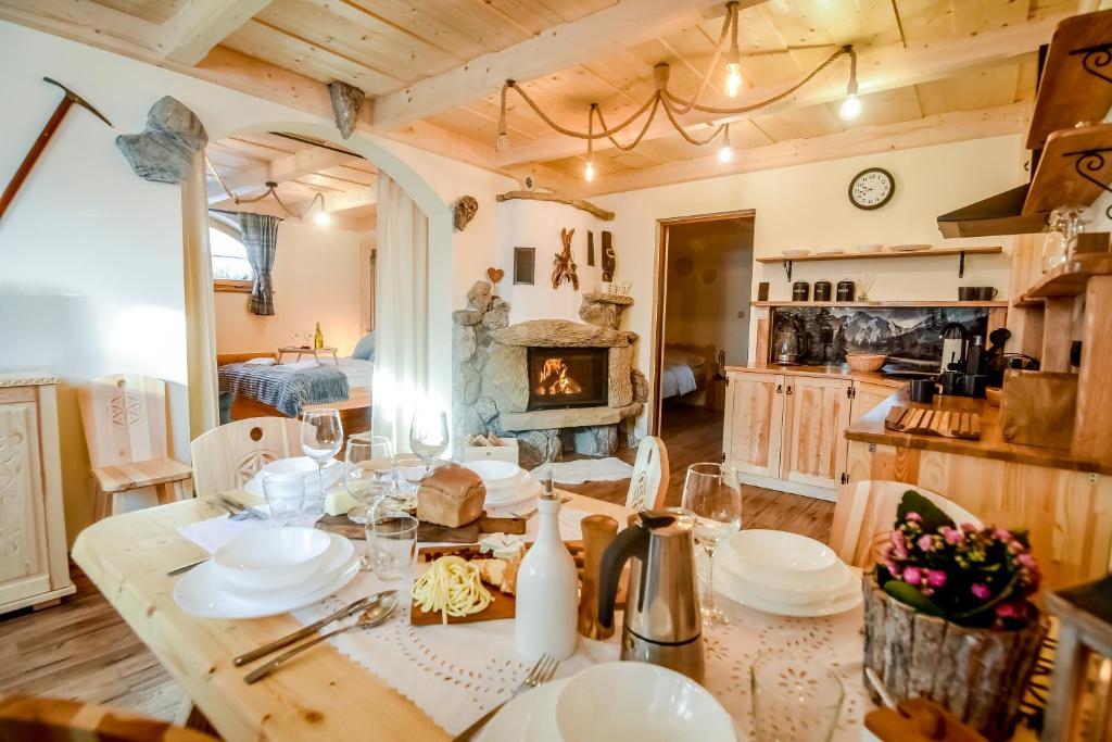 una sala da pranzo con tavolo e camino di Tatra Góral Ski Apartament a Murzasichle
