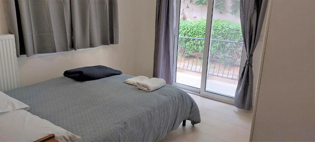 a bedroom with a bed with two towels on it and a window at Cozy apartment in Nea Smyrni in Athens