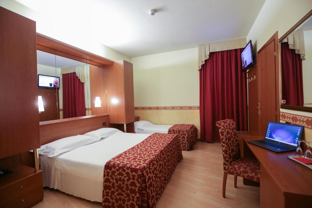 Habitación de hotel con cama, escritorio y ordenador portátil en Felix Hotel, en Montecchio Maggiore
