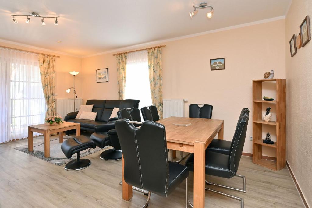 a living room with a table and chairs and a couch at Ferienpark Freesenbruch Reihenhaus 5c - Hummer in Zingst