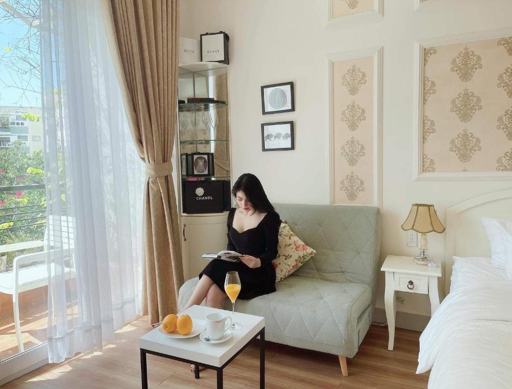 a woman sitting on a couch in a living room at Chez Lotus Rose in Ho Chi Minh City