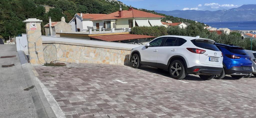 a couple of cars parked next to a wall at Old Town Baska in Baška