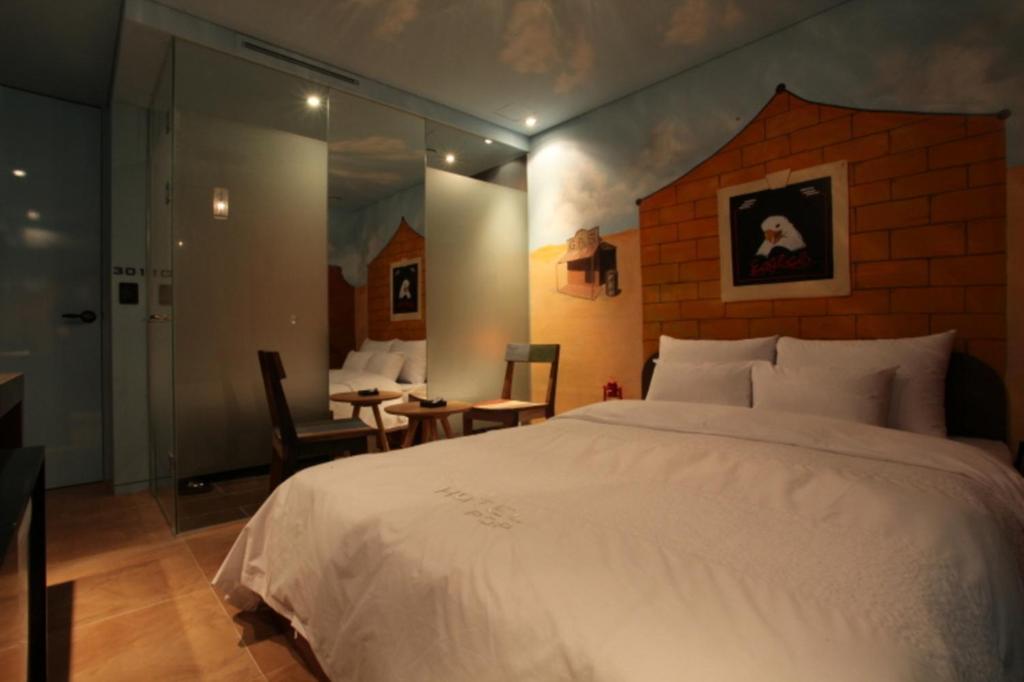 a bedroom with a large bed and a table and chairs at Hotel Pop2 Jongno in Seoul