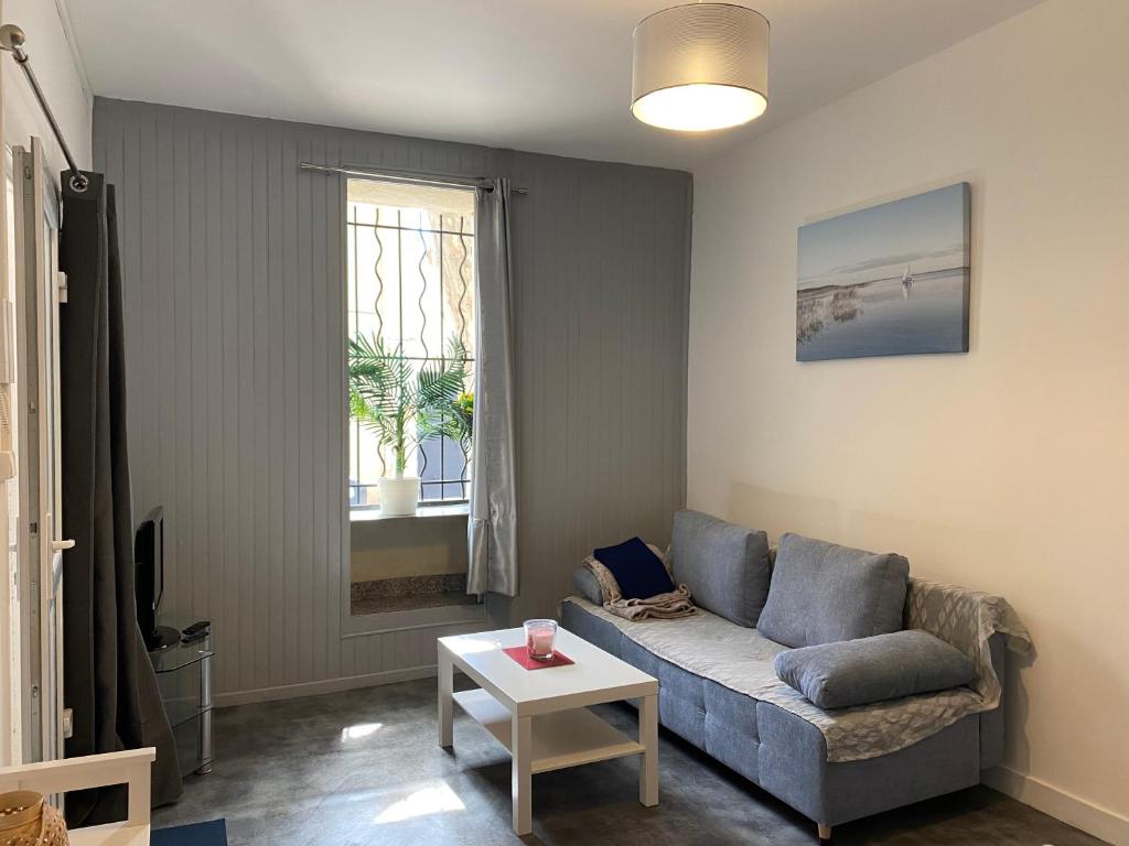 un salon avec un canapé et une table dans l'établissement Studio indépendant dans maison de ville, au calme, à Marseille