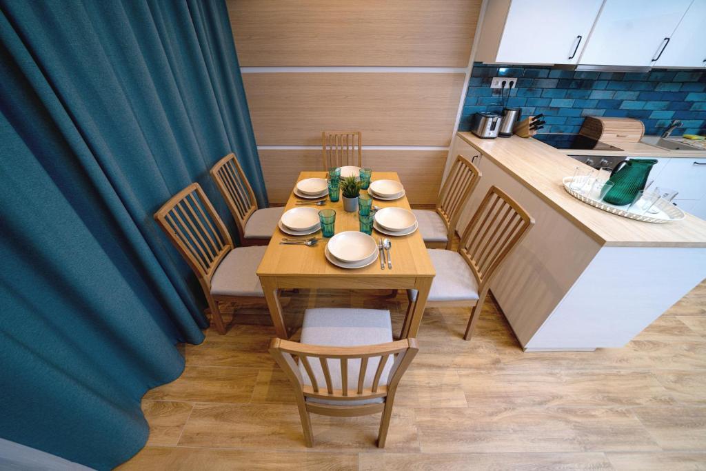 a dining room with a table and chairs and a kitchen at Master Resorts in Balatonkenese
