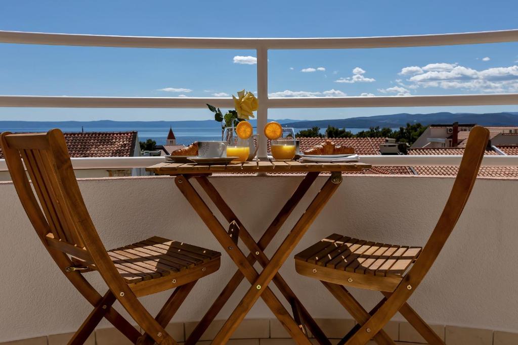 a table on a balcony with a view of the ocean at Newly renovated apartment with a beautiful sea view Emili in Promajna