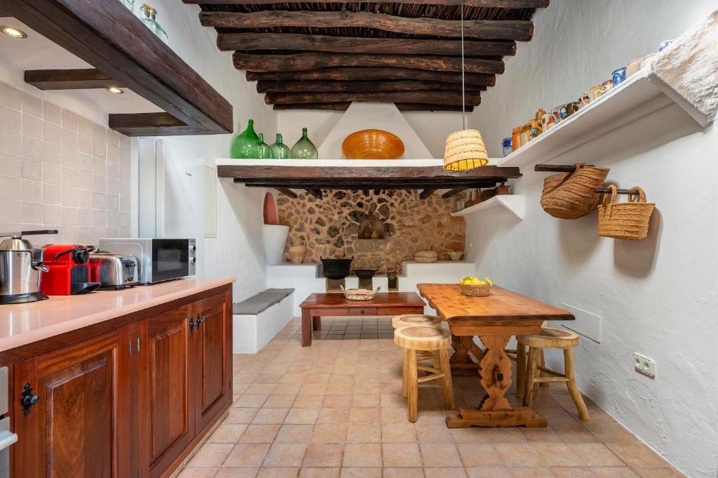 a kitchen with a wooden table and a dining room at Can Mateu in Santa Eularia des Riu