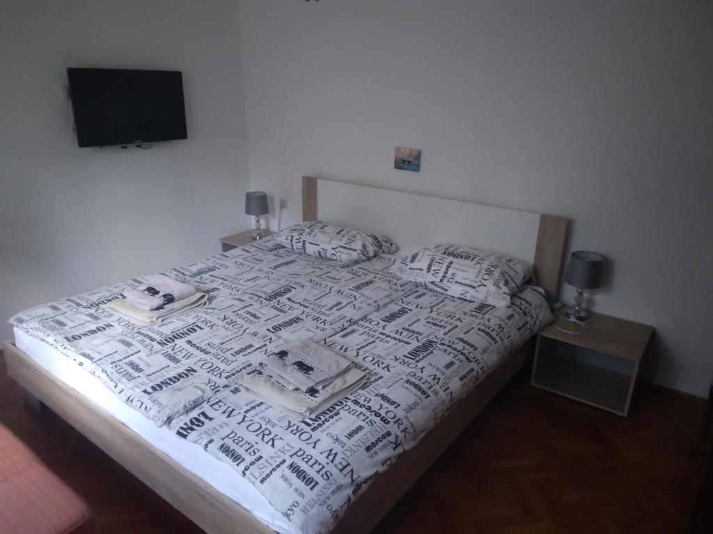a bedroom with a bed with a white comforter and a television at Apartments Villa Anton in Poreč