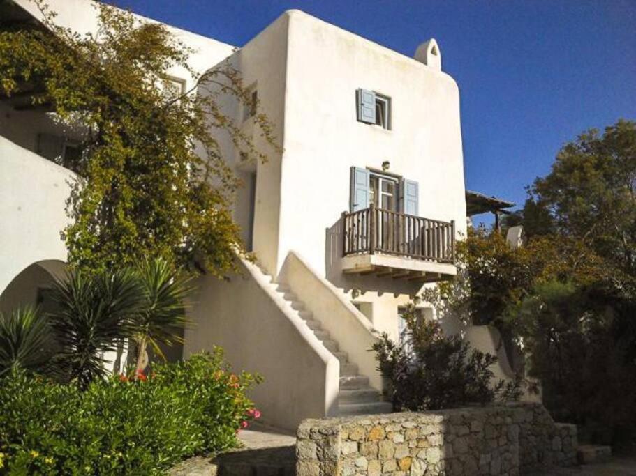 un edificio bianco con balcone e scale di MY CYCLADIC HOME , 5 min walk to Ornos beach a Ornos